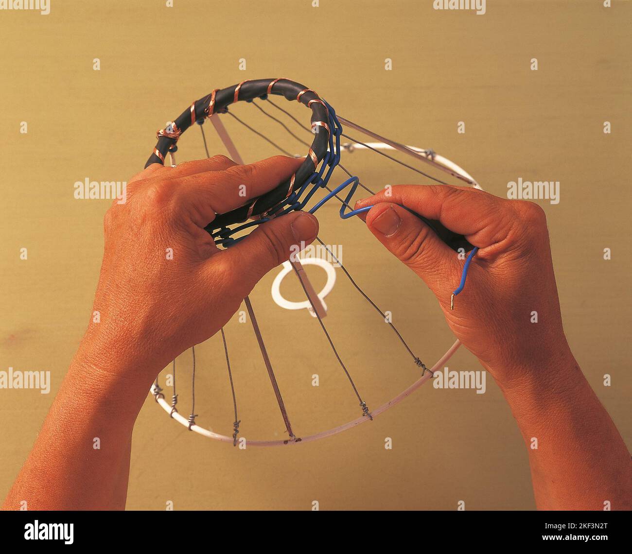 Twisting a blue cable around a spoke Stock Photo