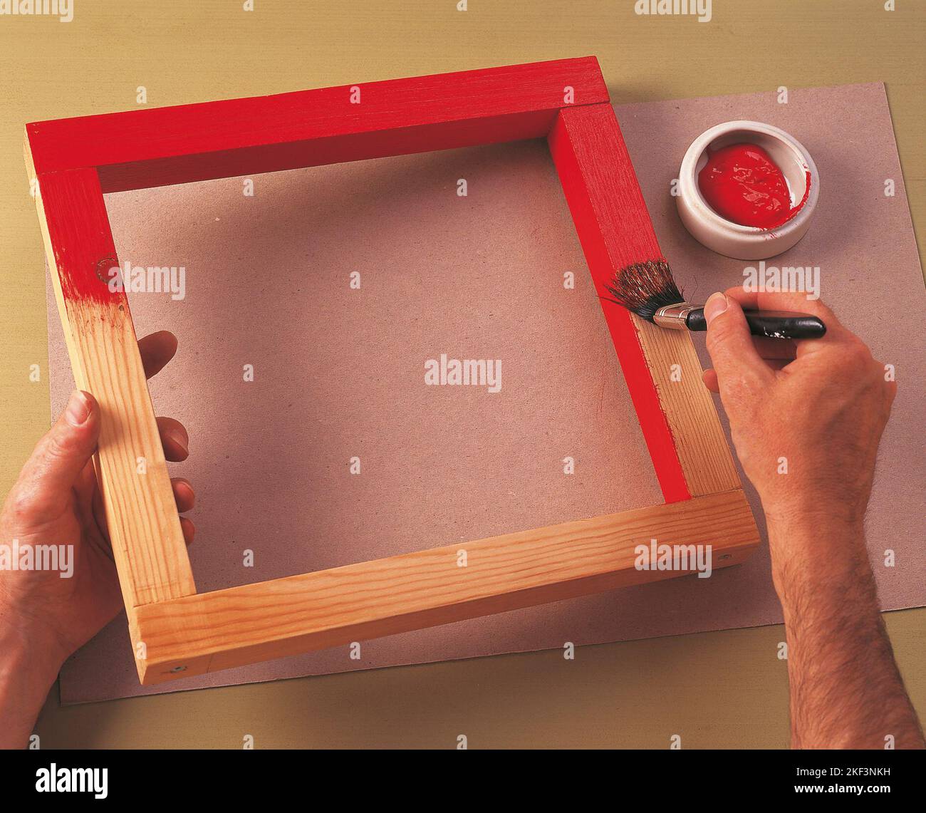 Painting the frame with bright red emulsion Stock Photo Alamy