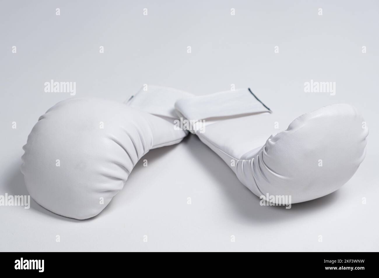 White boxing gloves for a child to practice karate or other martial
