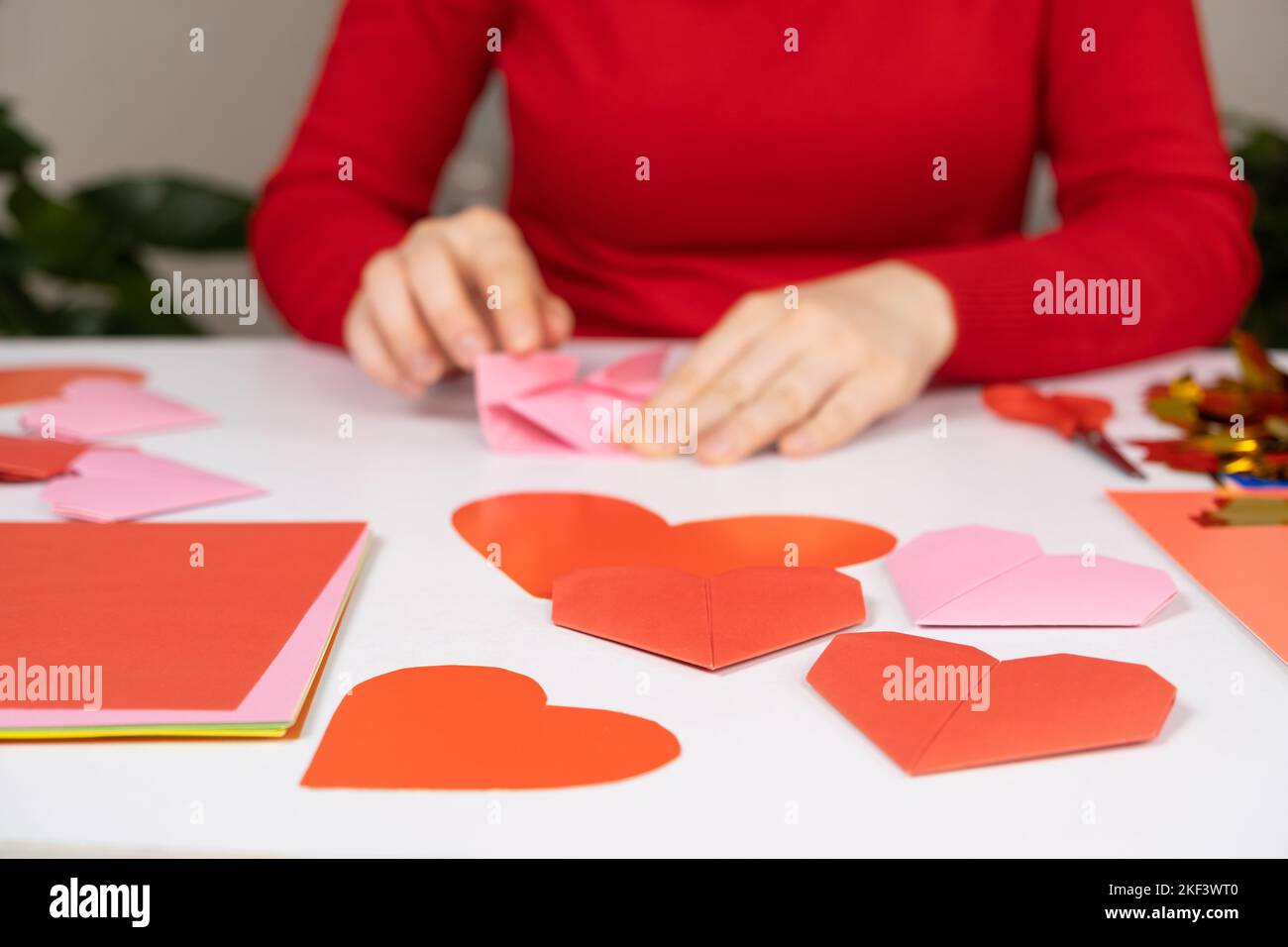 Making origami hearts for Valentine's Day. Crafts made of paper with your own hands. Stock Photo