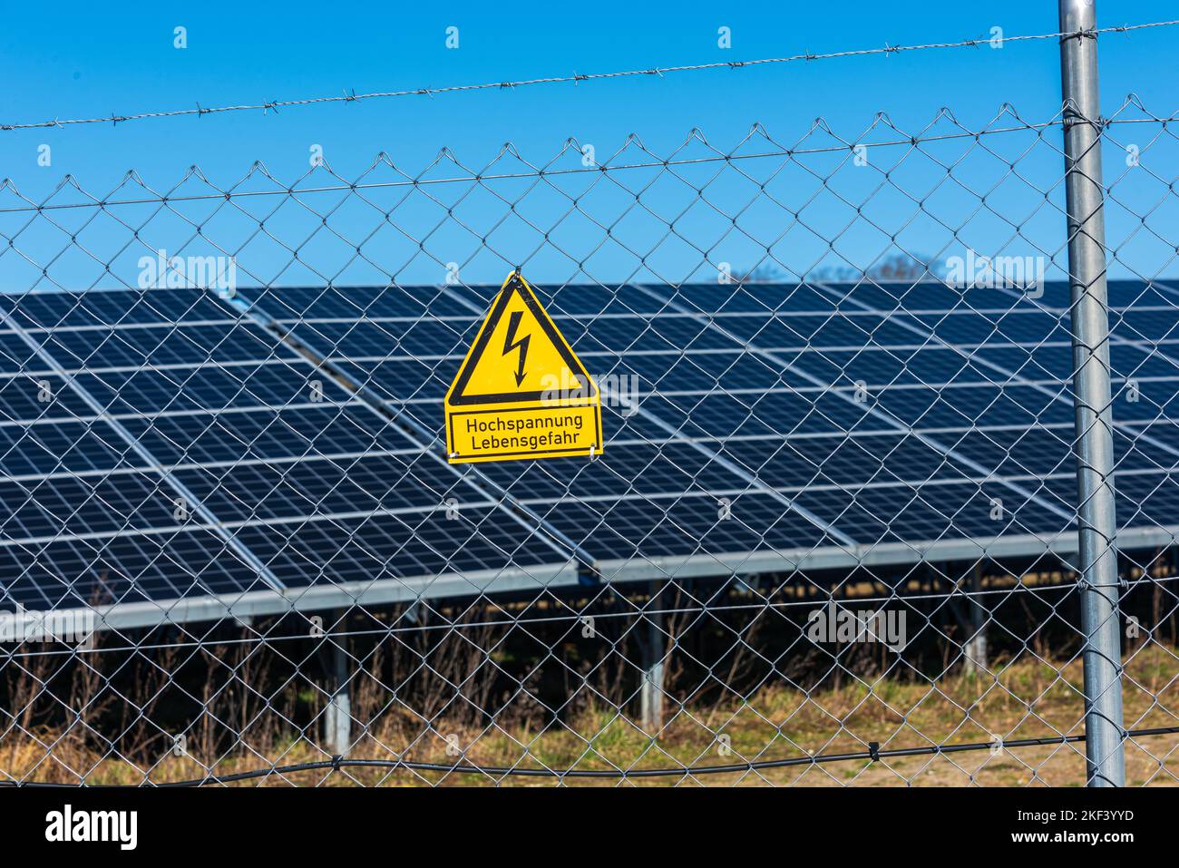 Schleswig-Holstein, Deutschland, März 2022 Schild Hochspannung Lebensgefahr. Photovoltaikanlage zur Stromerzeugung am Rande einer Autobahn Stock Photo