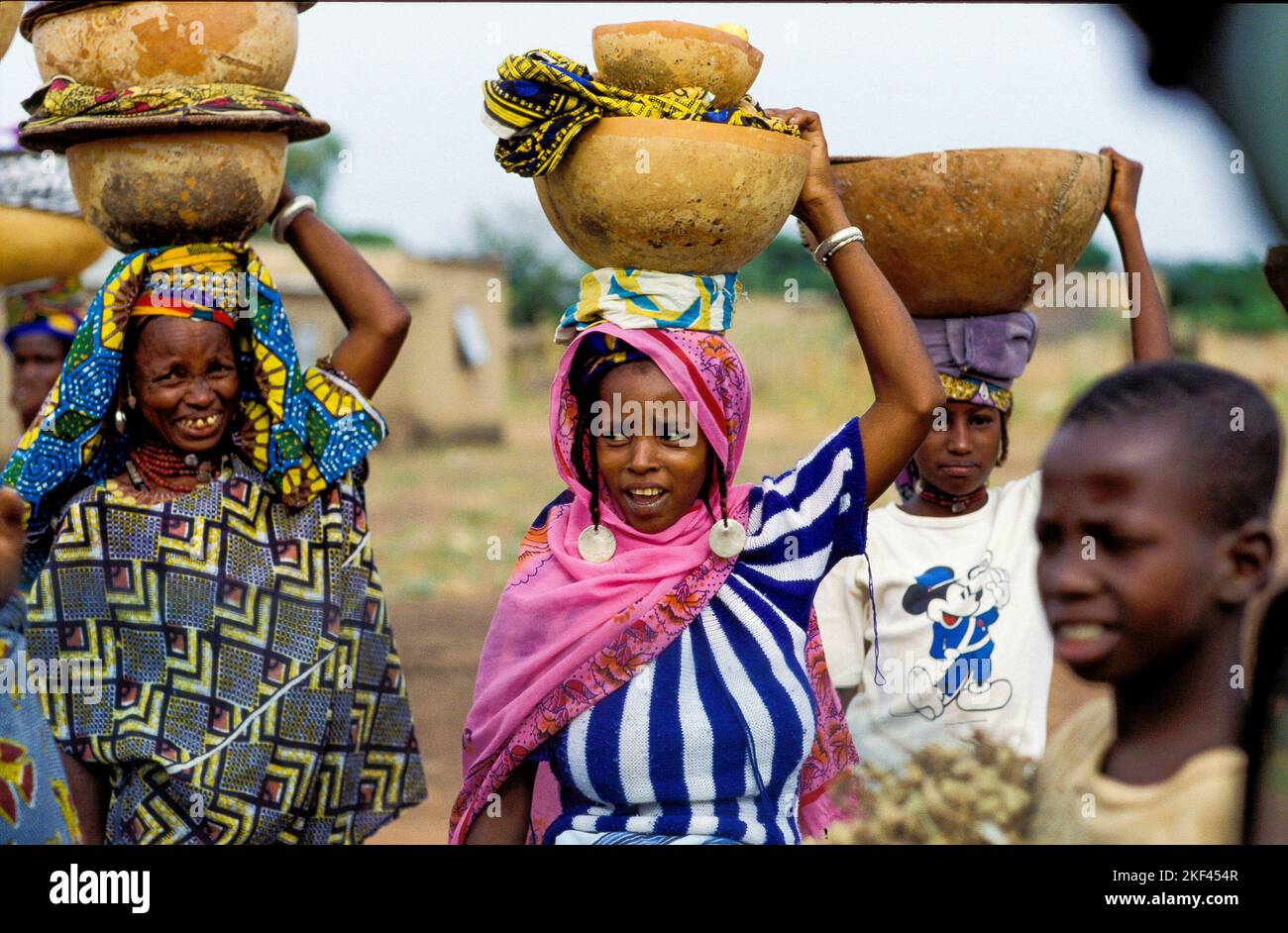 Burkina Faso, Fada Peuhl women are carrying bowls made of gourd on their heads on their way home from the market. Stock Photo