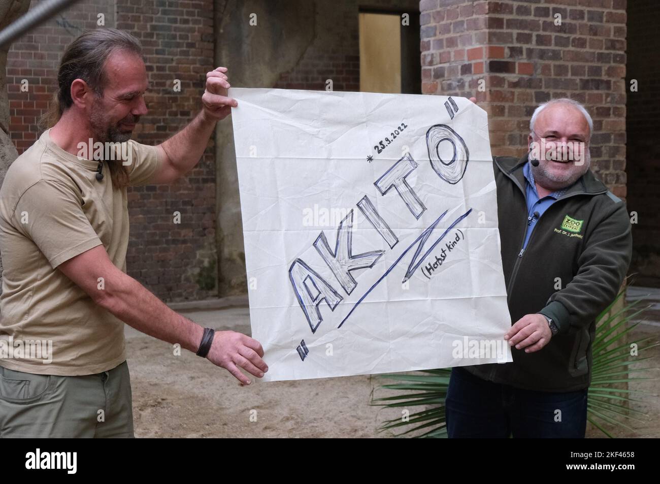Leipzig, Germany. 16th Nov, 2022. Thomas Günther (l), animal keeper, and Jörg Junhold, zoo director, hold a cloth with the name 'Akito' in their hands. Born on Sept. 25, 2022, the Asian elephant was christened Akito after a vote by zoo visitors, which translates as 'autumn child.' Credit: Sebastian Willnow/dpa/Alamy Live News Stock Photo