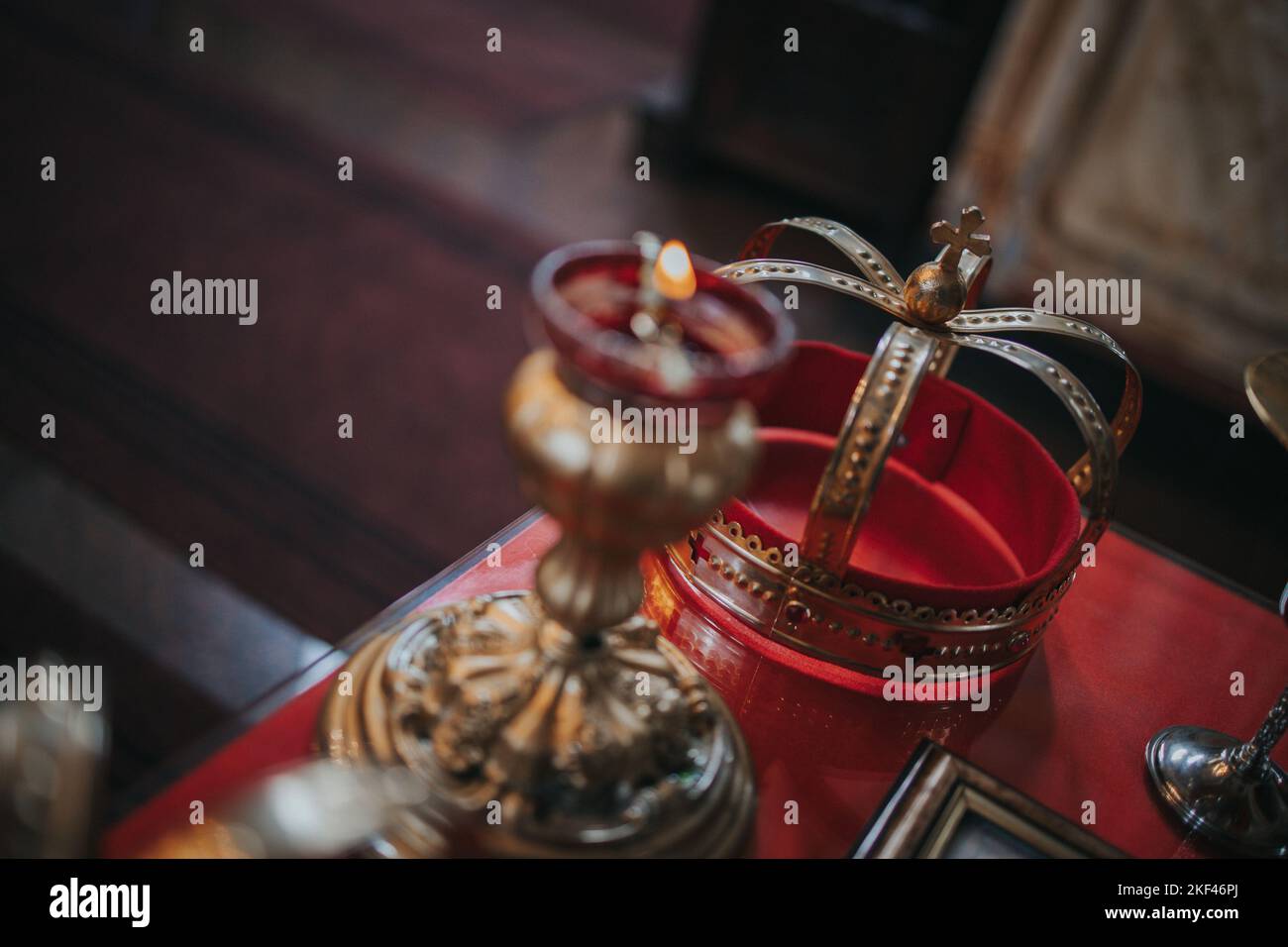 A selective focus of a golden crown and a candlestick laying on a ...