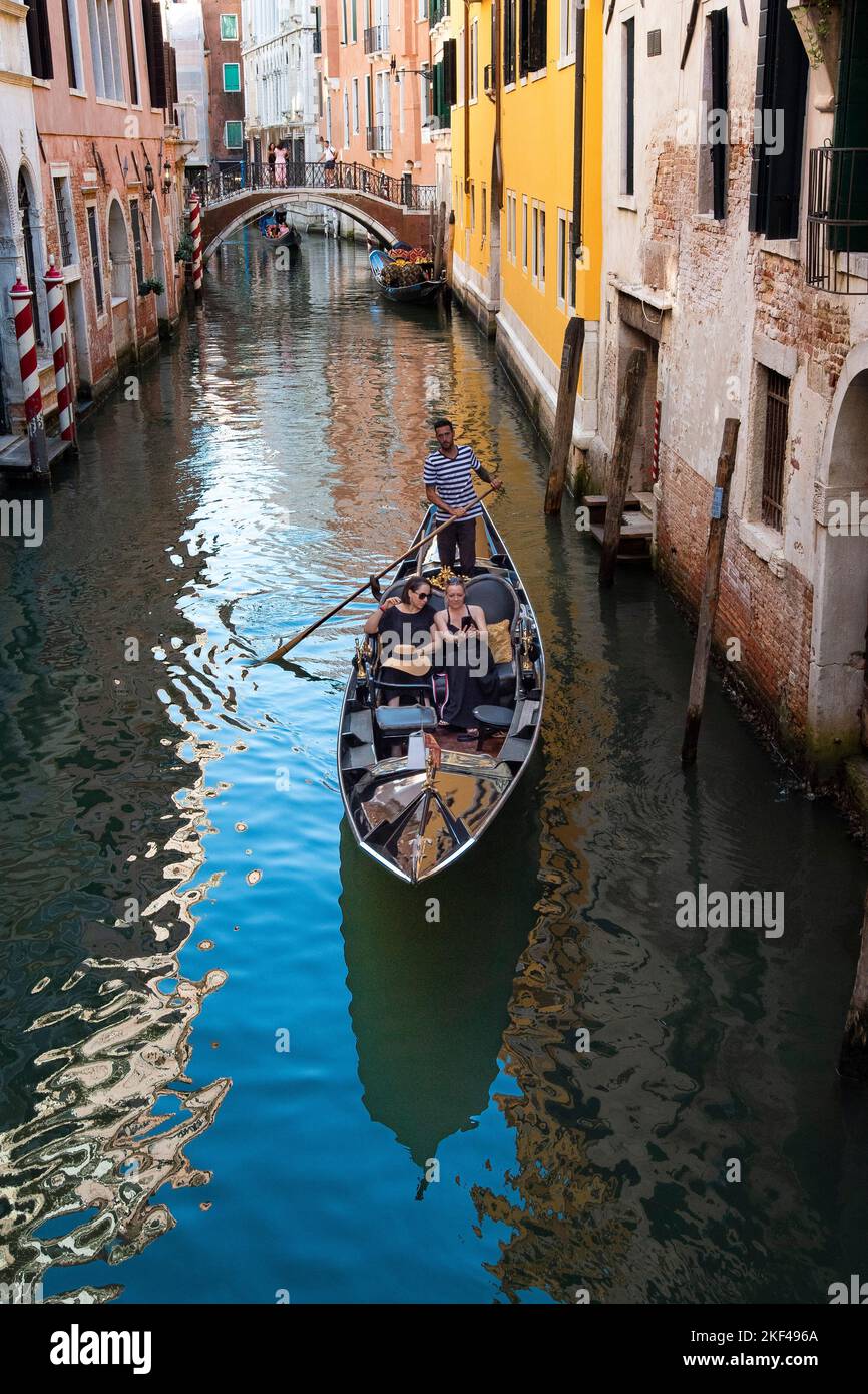 Venezianische Gondel mit Touristen im Kanal, Brücke mit Spiegelung im Kanal, Venedig, Venetien, Italien Stock Photo