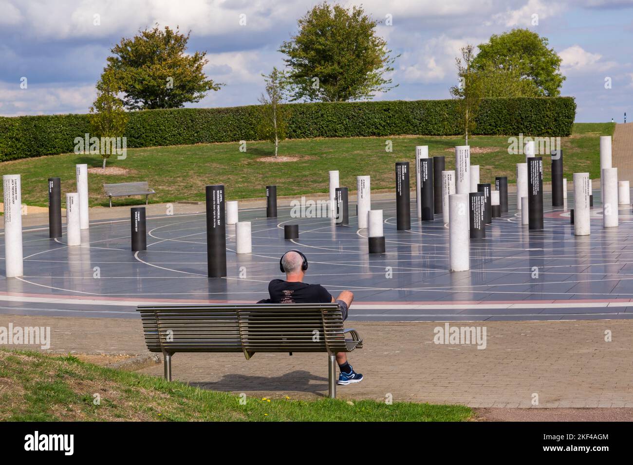 Man sitting relaxing on bench by The Milton Keynes Rose in Campbell Park at Milton Keynes, Buckinghamshire, UK in September MK Stock Photo