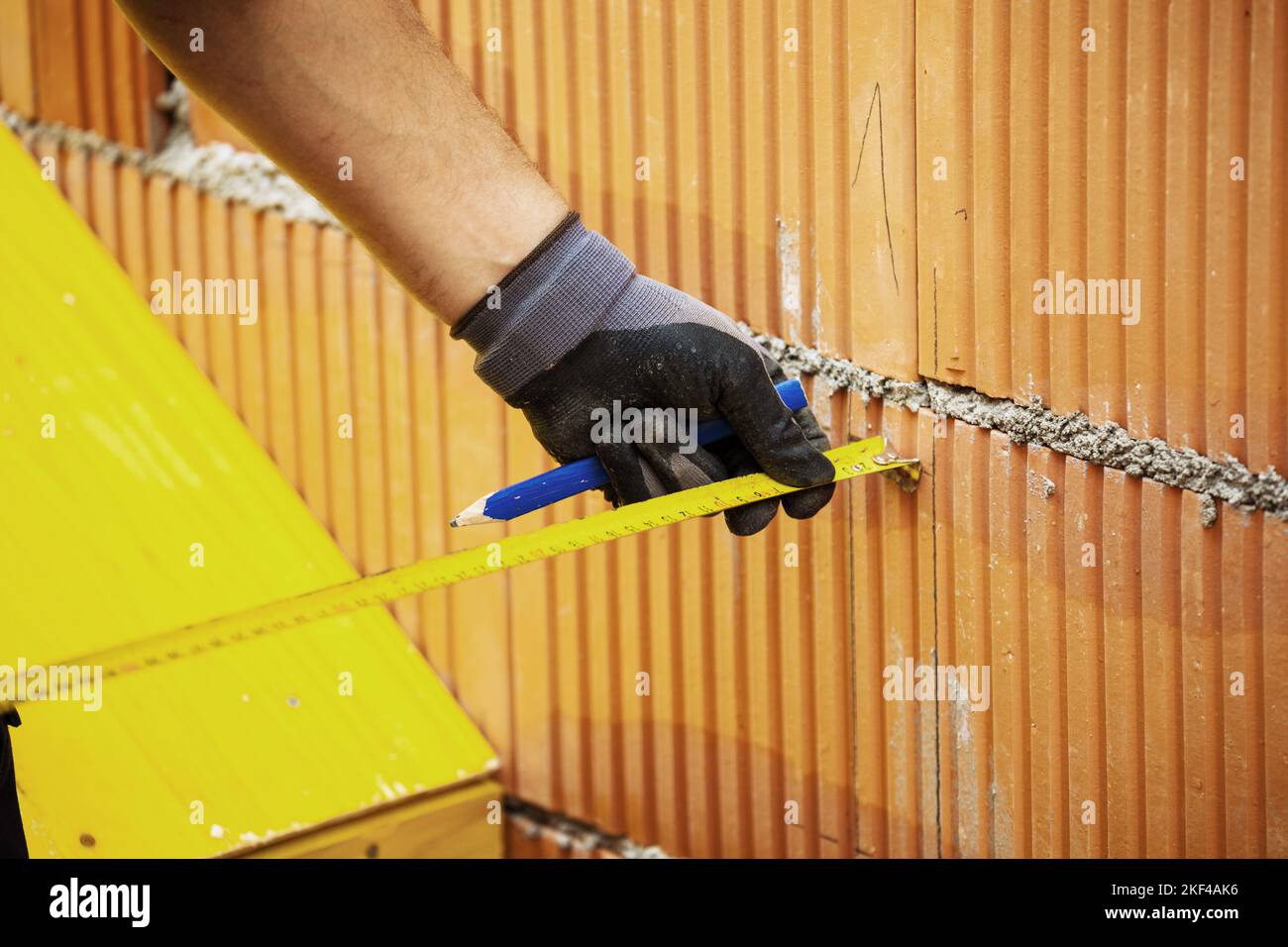 Ein Maurer beim Mauern eines Rohbaus in Massivbauweise. Ziegelmauer eines Einfamilienhauses Stock Photo