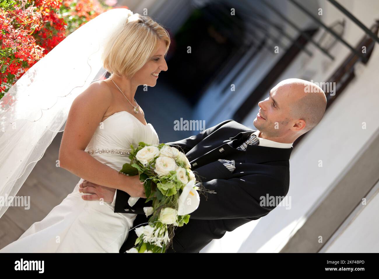 Ein glückliches Brautpaar mit Brautstrauss freut sich über die Hochzeit, Blond, Blonde, Blondine, 30, 35, Jahre, Anzugträger, Stock Photo