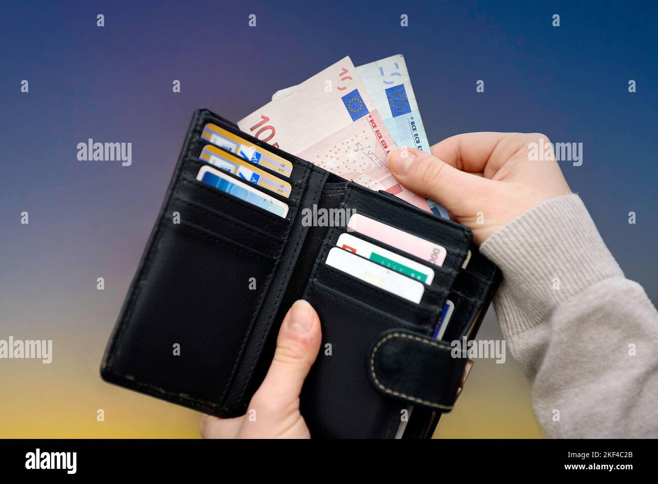 Eine Hand zieht Euro-Geldscheine aus Geldbeutel, Preissteigerung, Teuerungsrate, Hartz IV, Rente, Grundeinkommen, Bürgergeld, Grundrente, Stock Photo