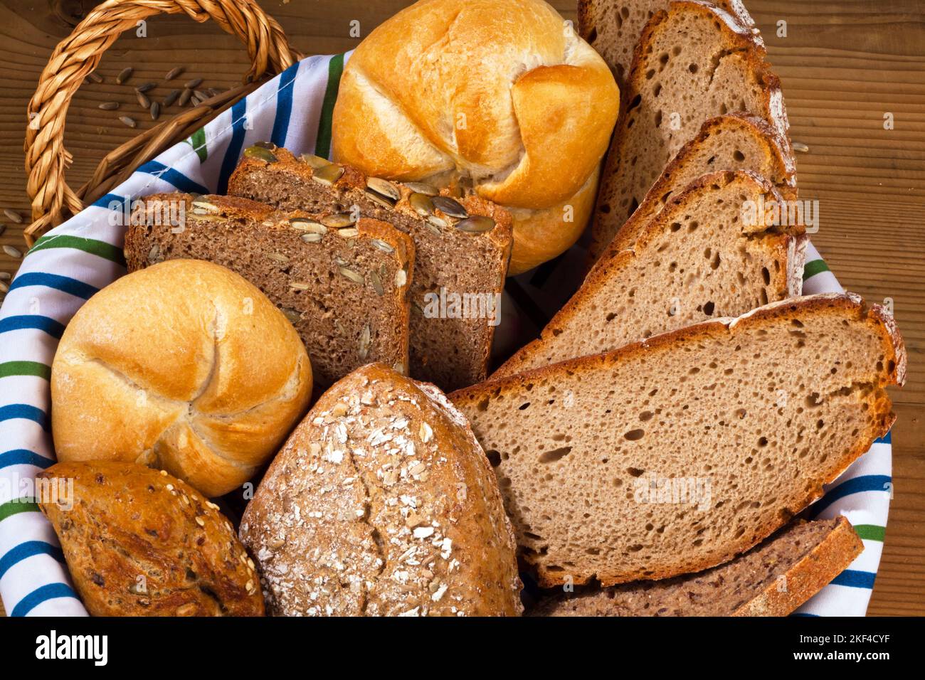 Ein Korb mit verschiedene Sorten Brot und Brötchen. Gesunde Ernährung durch frische Backwaren. Stock Photo
