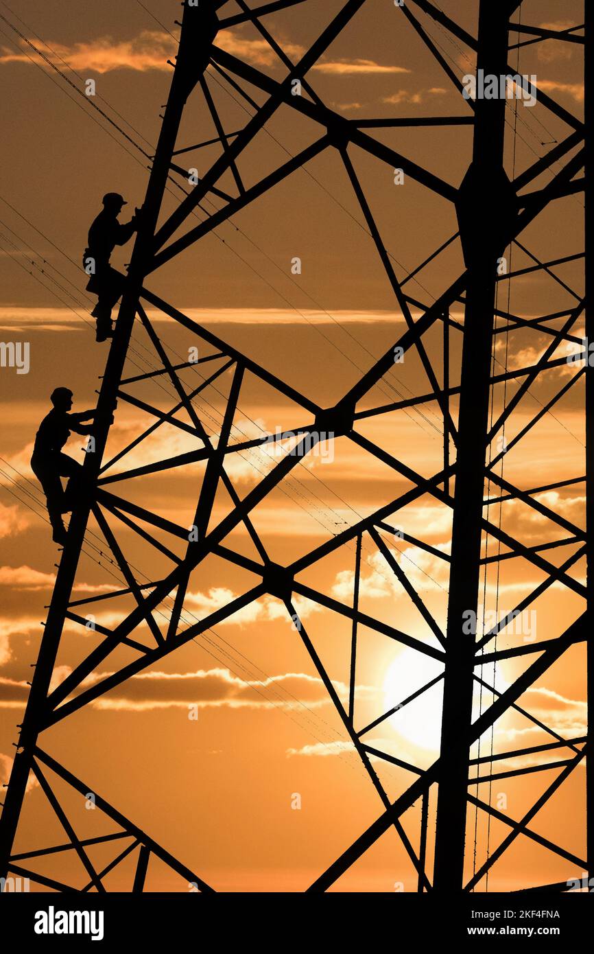 Elektriker reparieren Stromleitung am Strommast, Sonnenuntergang, Wirtschaftsaufschwung, Konjungtur, Aufwärts, Stock Photo