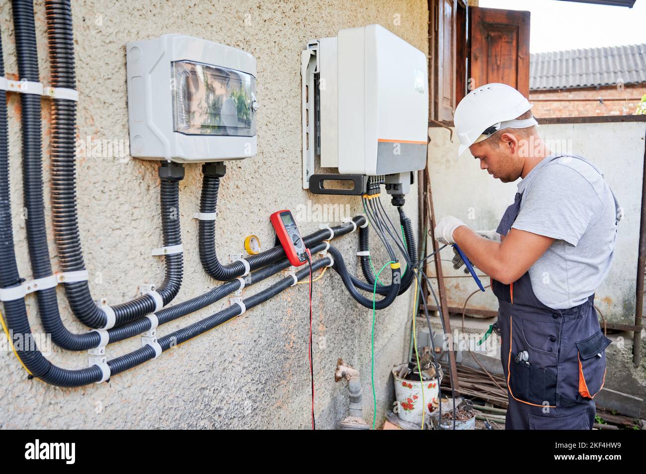 Man electrician installing solar panel system. Inspector in helmet and