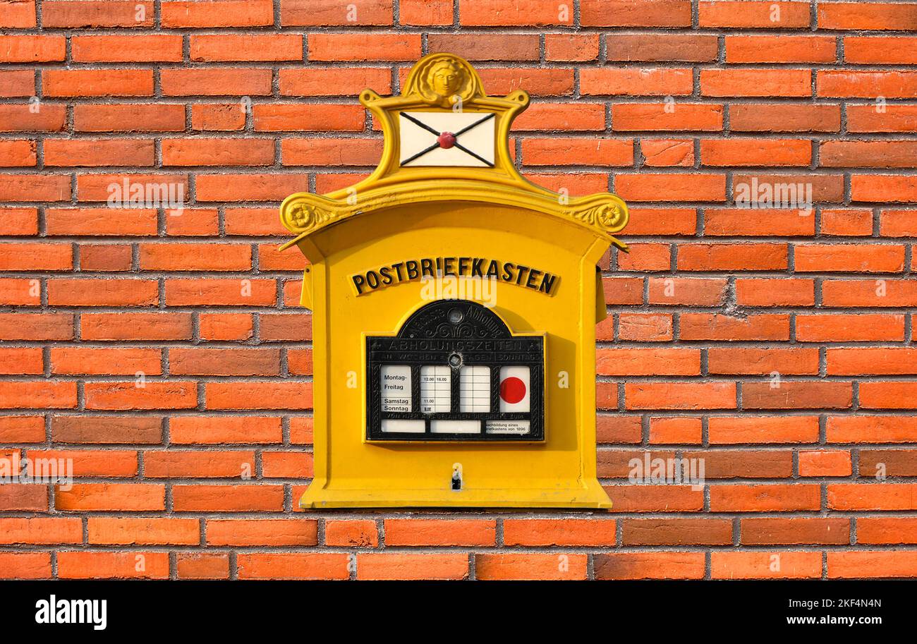 Eine rote Mauer und ein alter nostalgischer Postbriefkasten, Nachbildung eines Briefkastens von 1896, Replika, Nostalgie, Stock Photo
