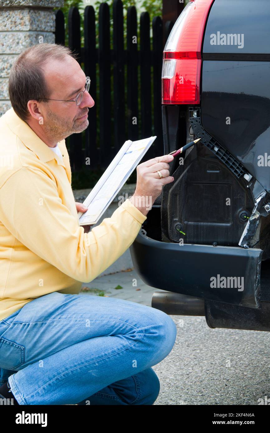 KFZSachverständiger einer Versicherung begutachtet einen Schaden am Auto. Autoversicherung