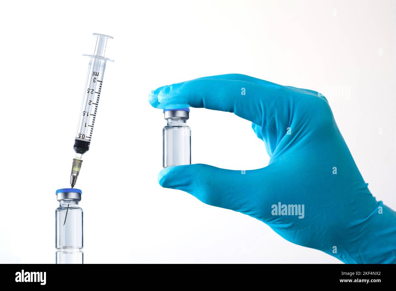 Eine Hand hält ein Glas mit Impfstoff,  Covid-19, Corona, Impfen, Impfdosis, BionTech, Pfizer, AstraZeneca, Novavax, Virus, Mutante, Affenvirus, Coron Stock Photo