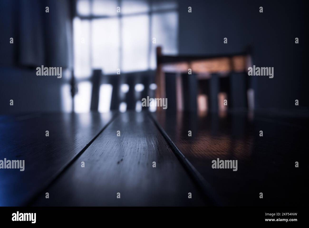 Low sunlight with shadows cast on a wall with table and chair Stock Photo