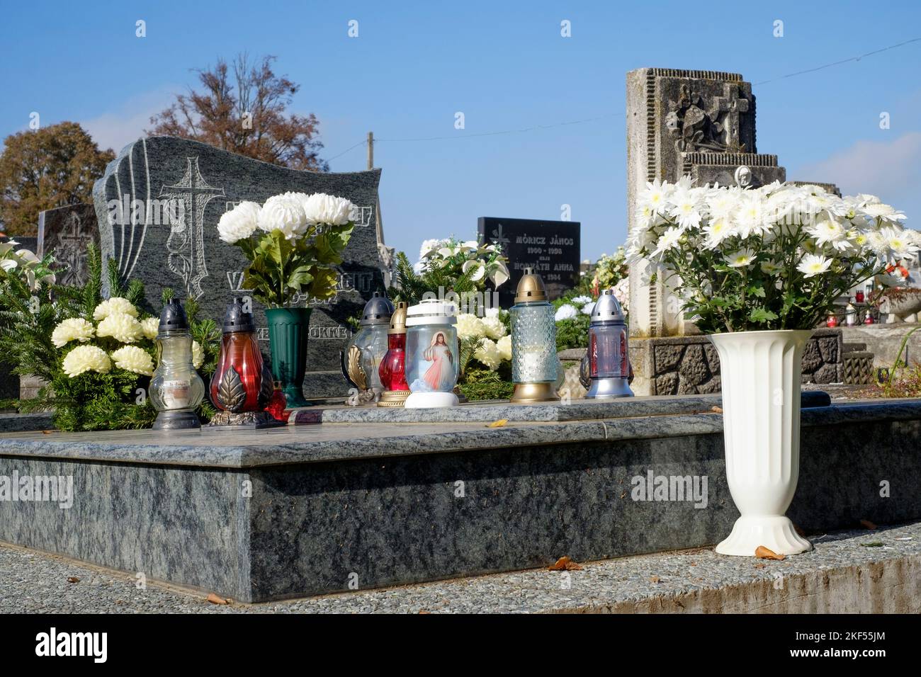 graves are decorated with fresh flowers candles lanterns at local rural cemetery for traditional all saints day zala county hungary Stock Photo