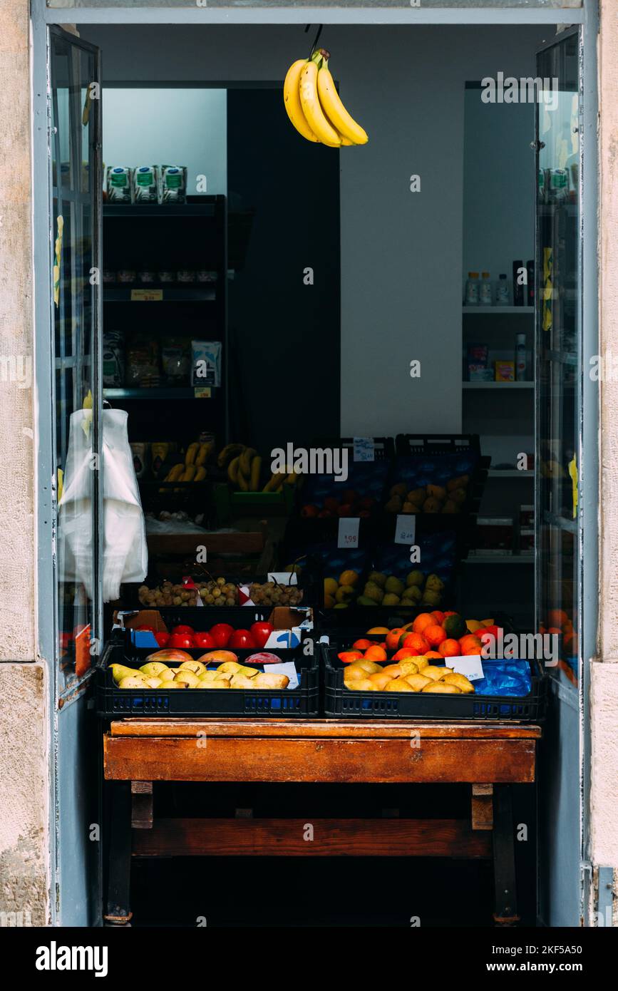 Entrance to a shop selling fresh fruit with bananas hanging from the doorway - captured in Lisbon, Portugal Stock Photo