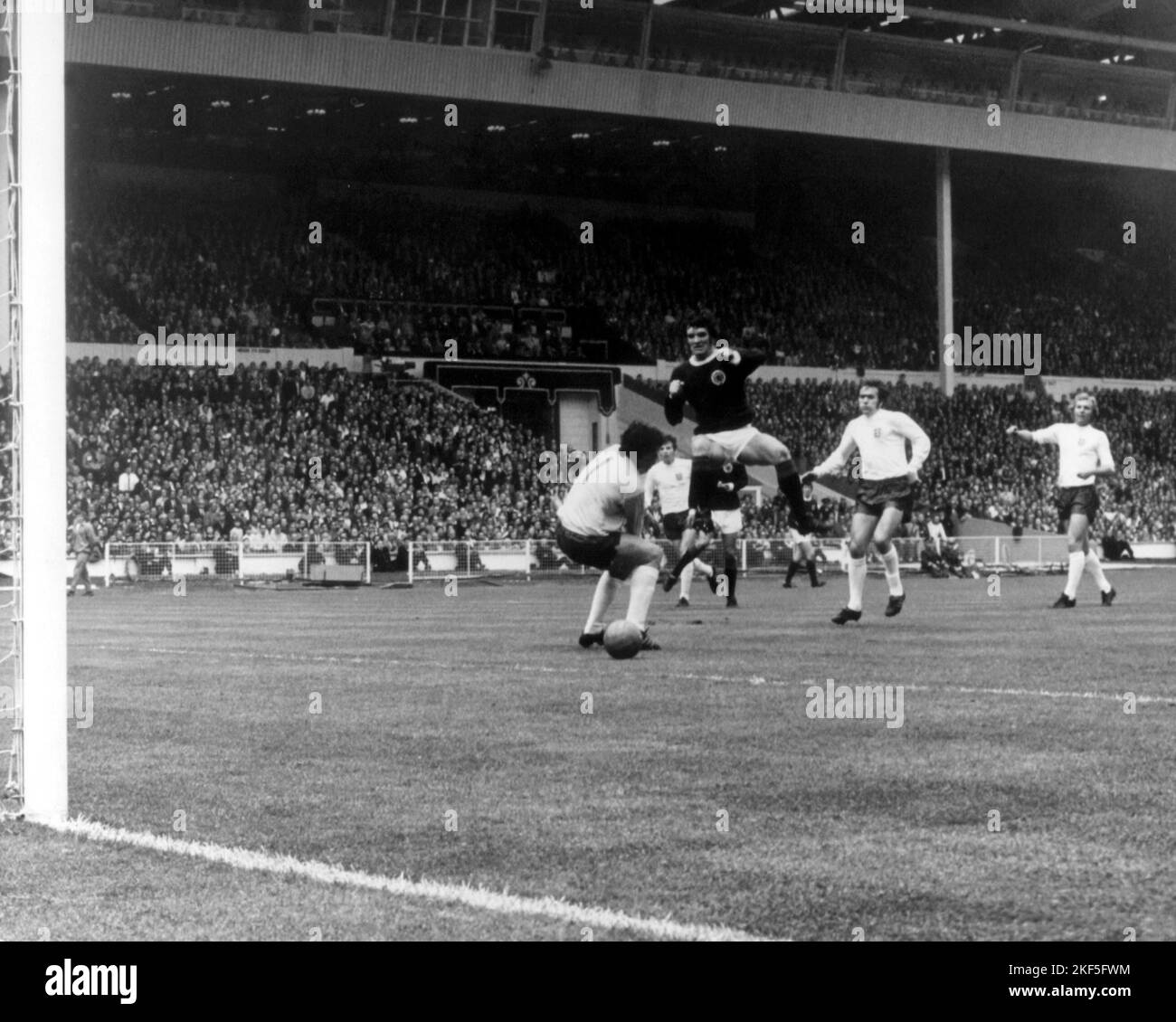 Scotland's Hugh Curran (second l) nips in to poke his team's only goal ...