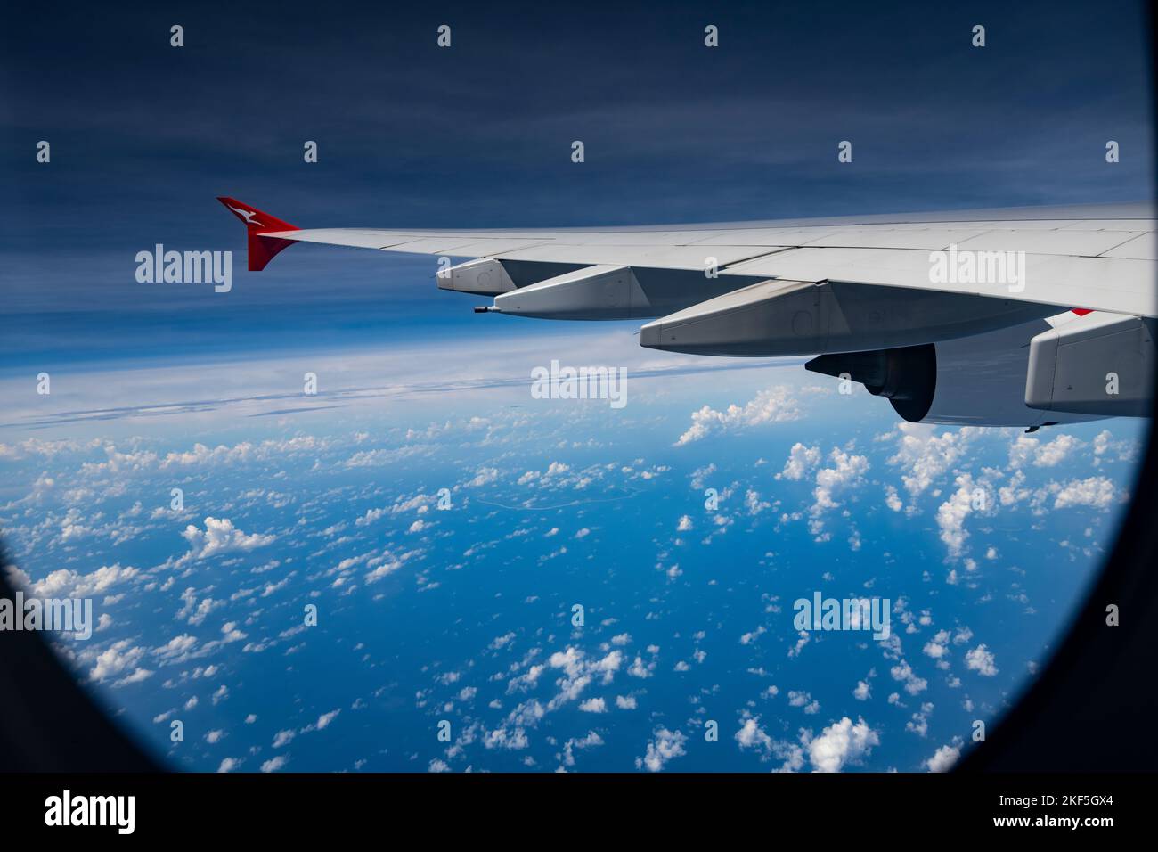 Wing of Australian Qantas airliner flying at 38,000 feet above Indian Ocean Stock Photo