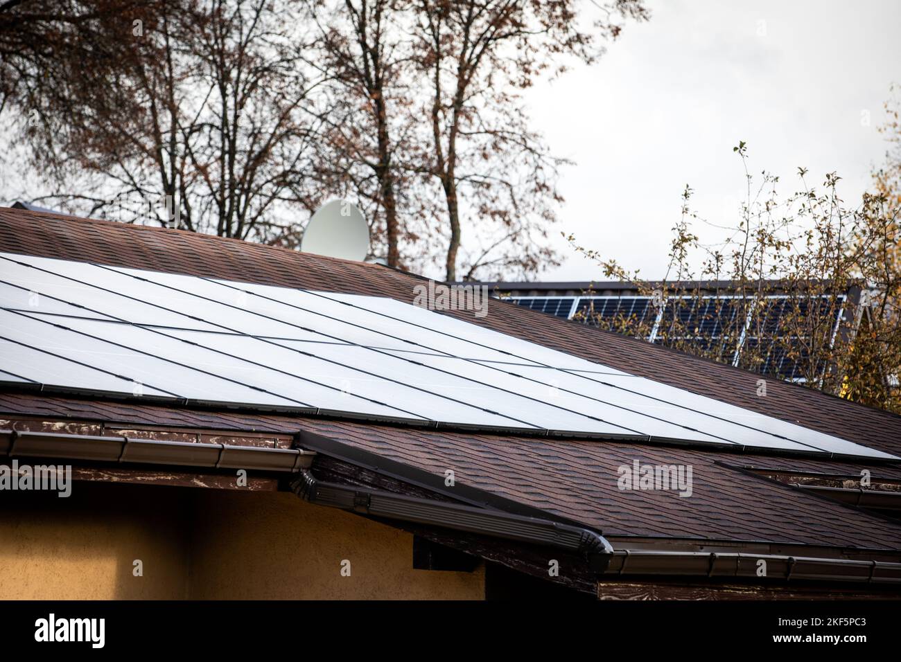 Solar panels on a shingle roof. Heating season, autumn and winter. Stock Photo