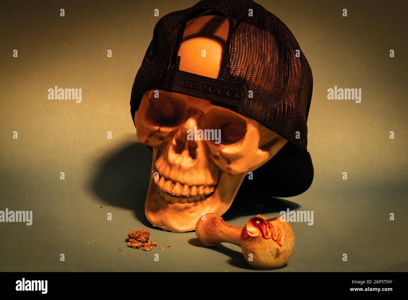 Skull wearing a backwards hat is ready to smoke a bowl of marijuana Stock Photo