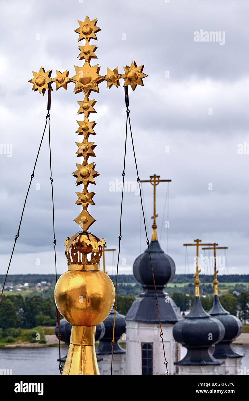 Eastern orthodox crosses on gold domes, cupolas, against blue sky with
