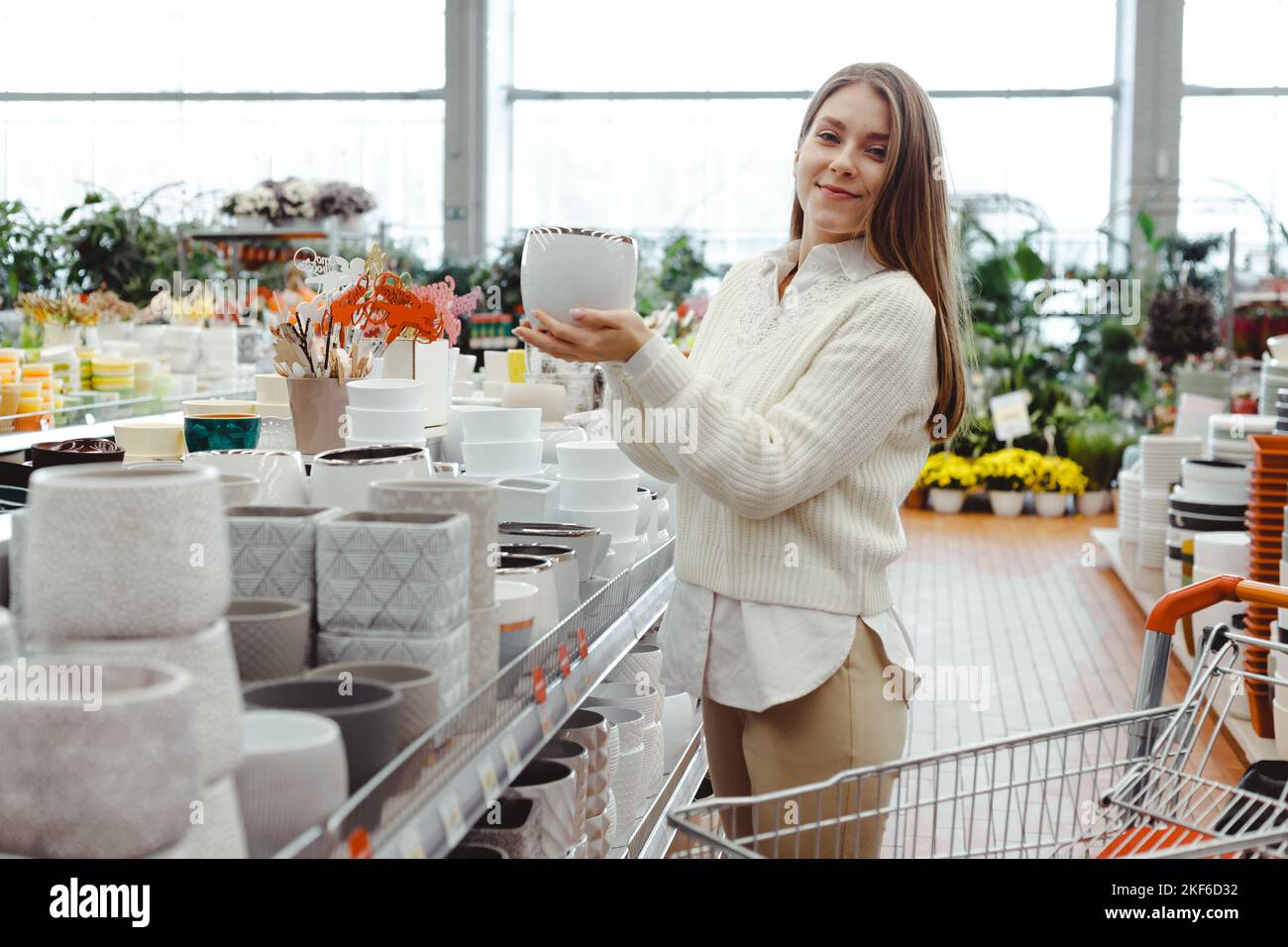 A woman chooses a pot for home plants in a greenhouse store, hardware store, shopping for home and interior goods. Stock Photo