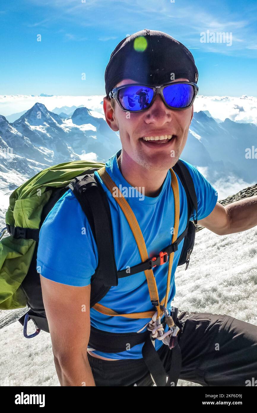 Description Mountaineer with crampons and ice axe hiking up steep snow