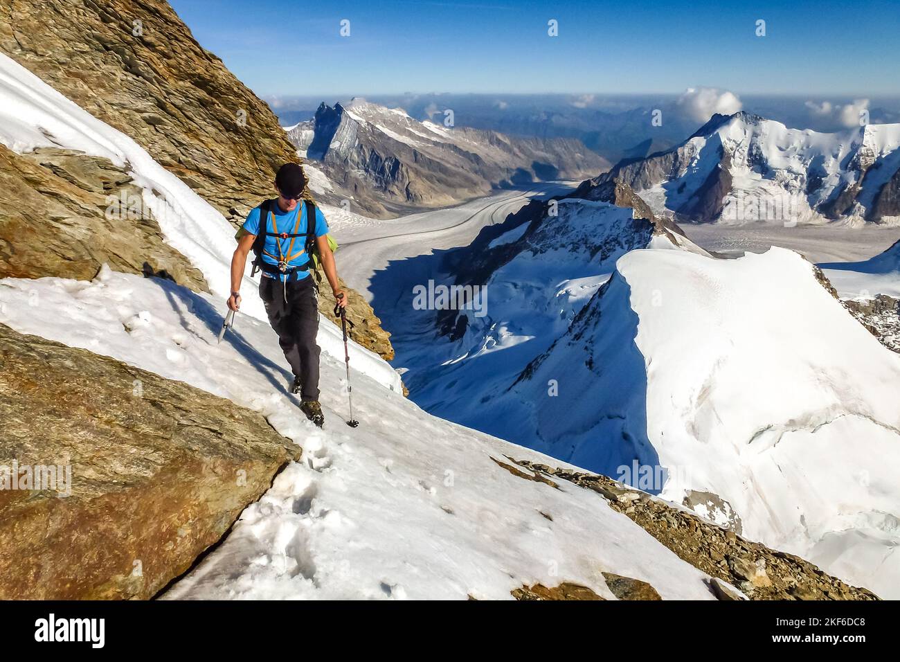 Description Mountaineer with crampons and ice axe climbing rocky