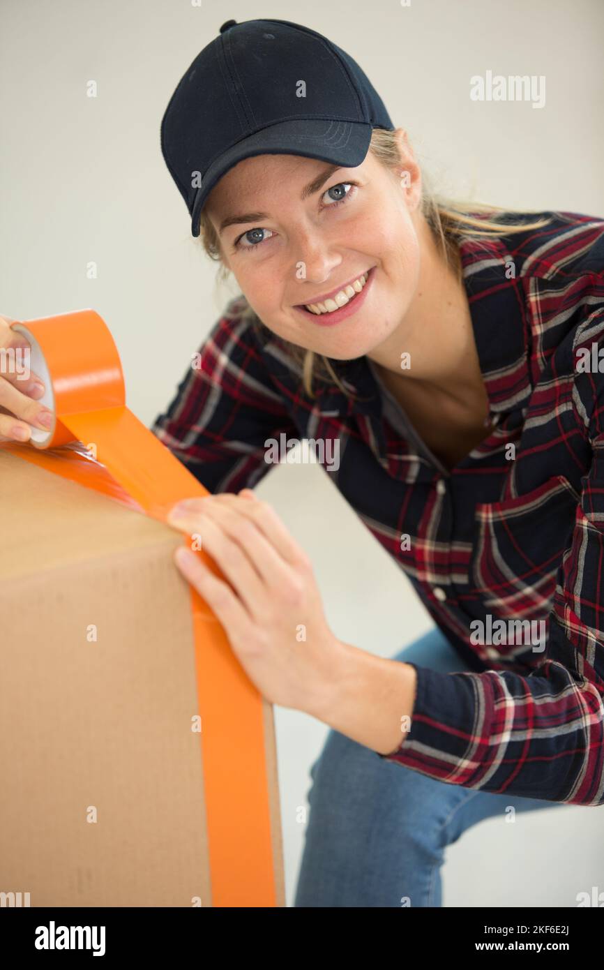 woman sealing cardboard box with adhesive tape Stock Photo Alamy