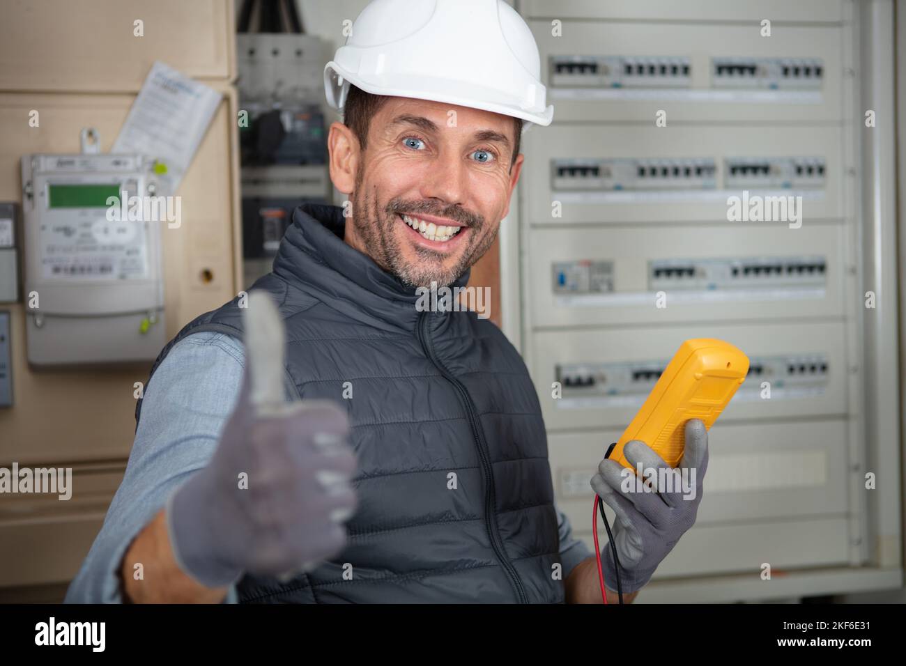 portrait of male electrician holding multimeter with thumbs-up Stock ...