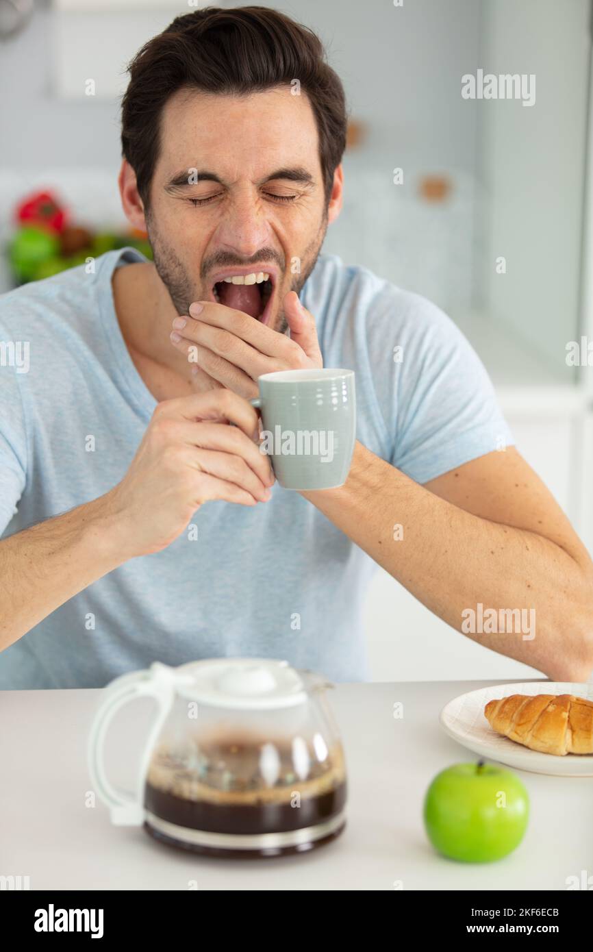 man falling asleep during his breakfast Stock Photo