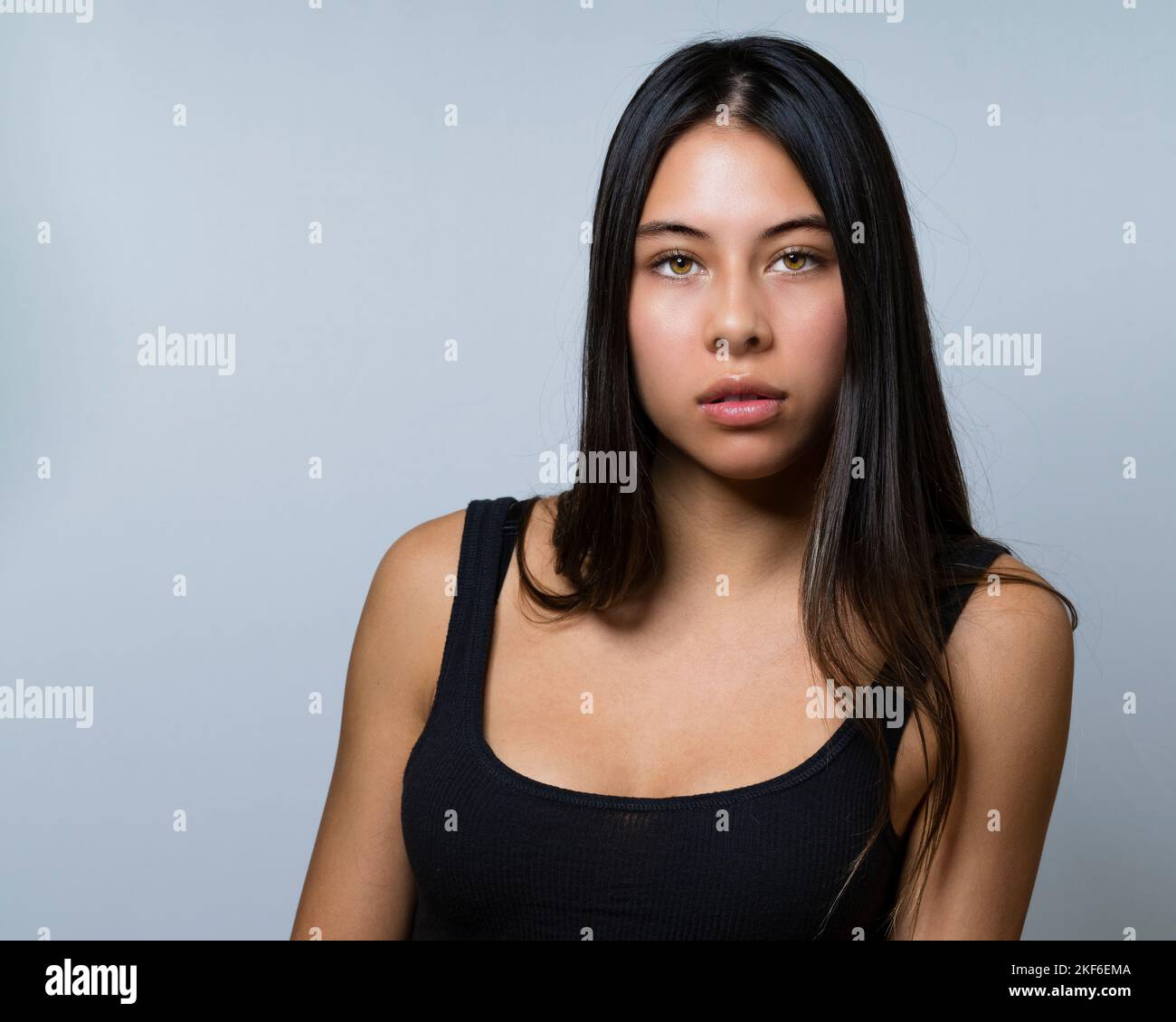 Close up of Multiracial Teen Female Seated with Intense Eyes and Long Hair 90s Vibe Stock Photo