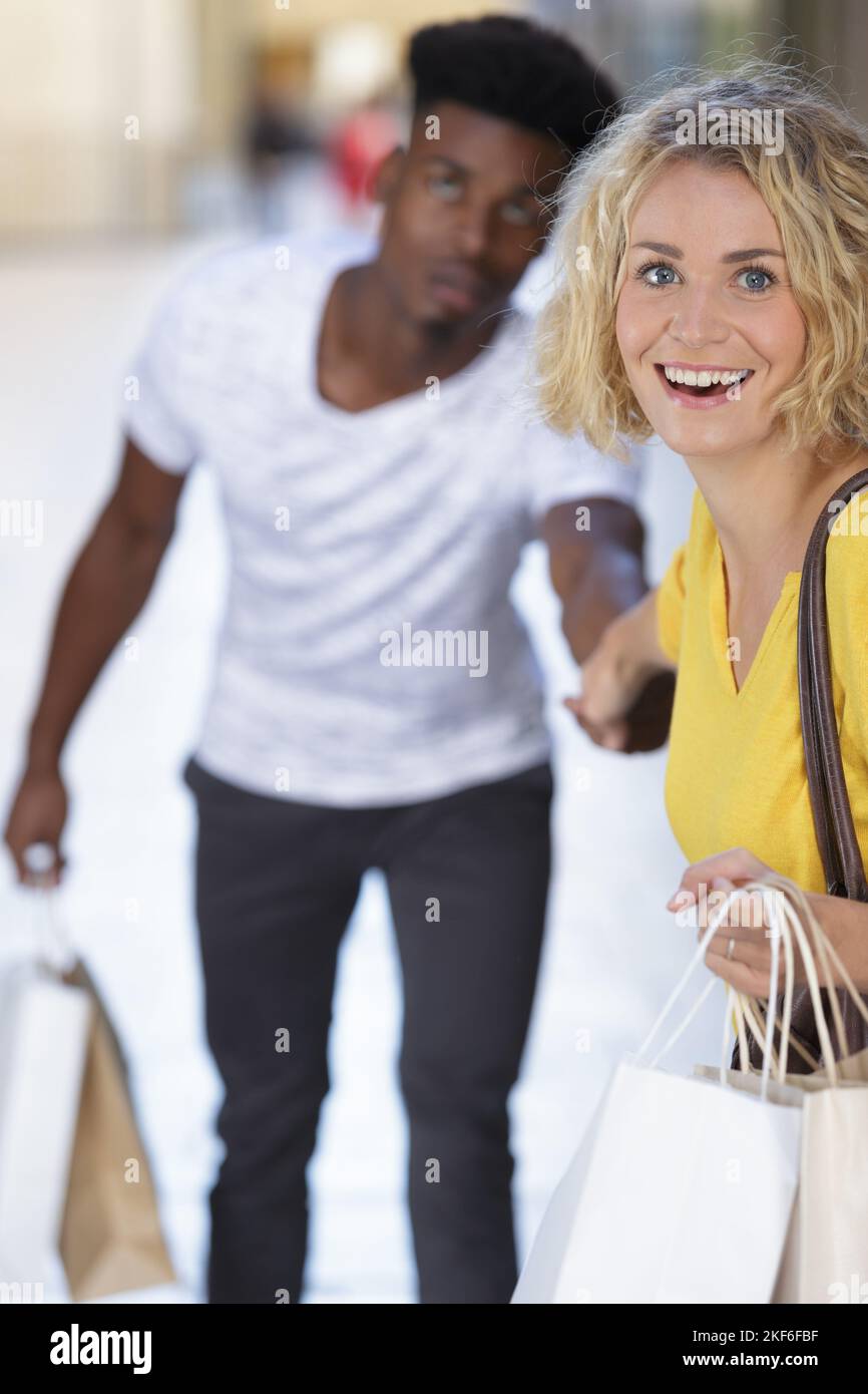 woman dragging her man to fashion shopping Stock Photo Alamy