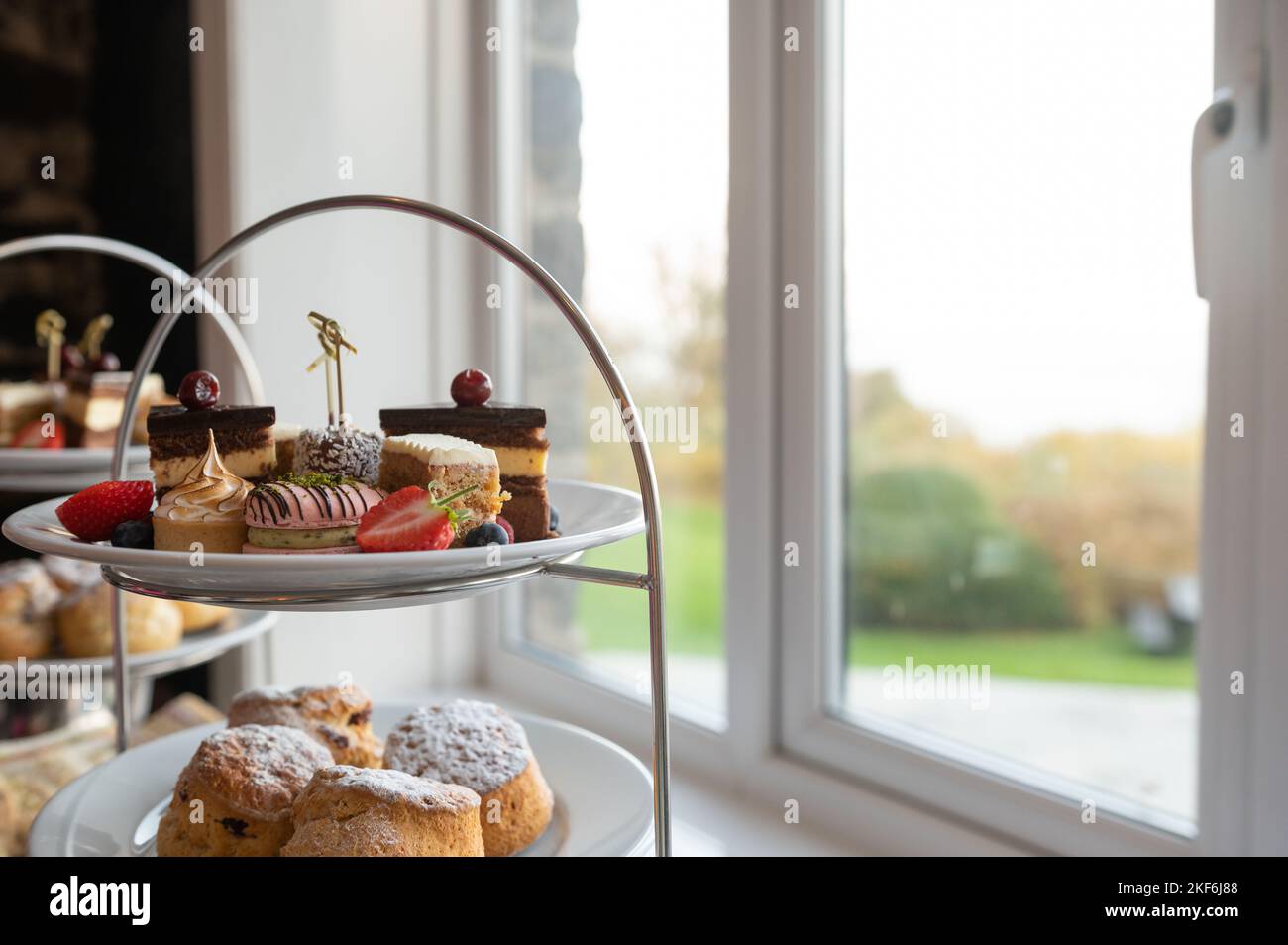 British afternoon tea cakes scones on English plate setting Stock Photo
