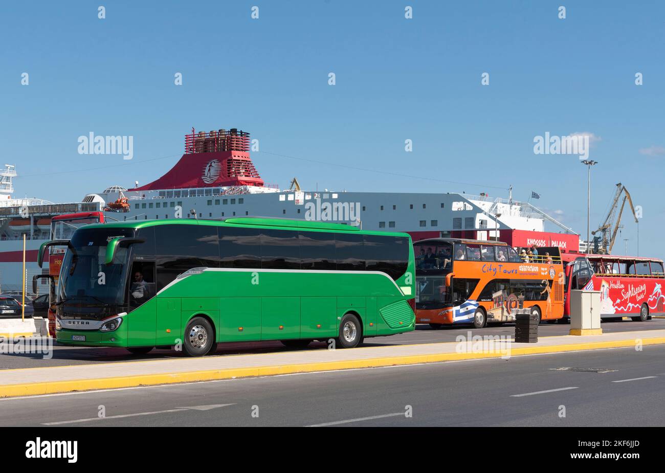 Heraklion, Crete, Greece. 2022. Hop on hop off city tour buses wait for tourists and a green coach for cruise ship passengers  in the Port of Heraklio Stock Photo