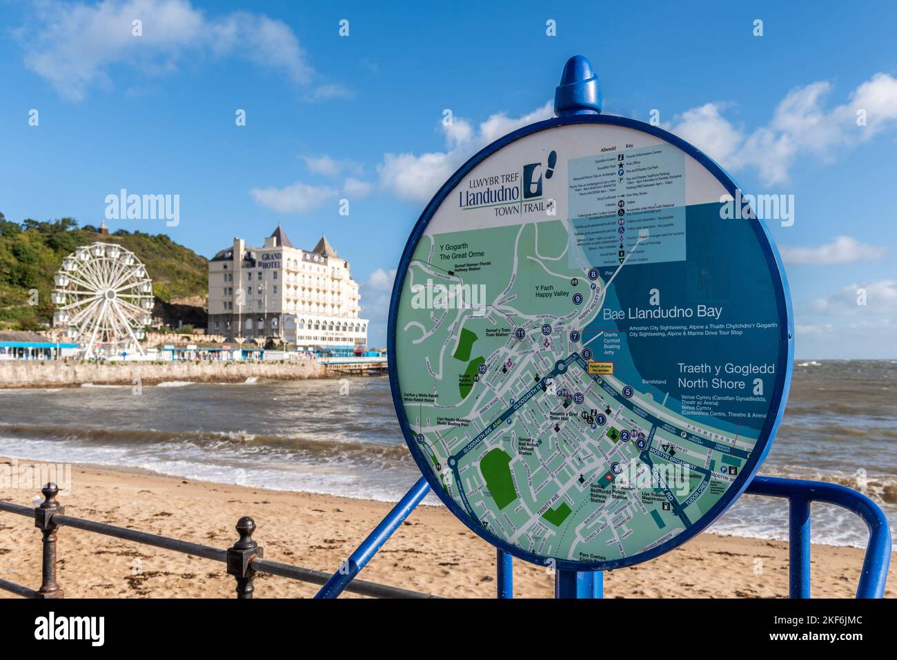 Information sign on the promenade with the Grand Hotel and ferris wheel in the background in Llandudno, North Wales, UK. Stock Photo