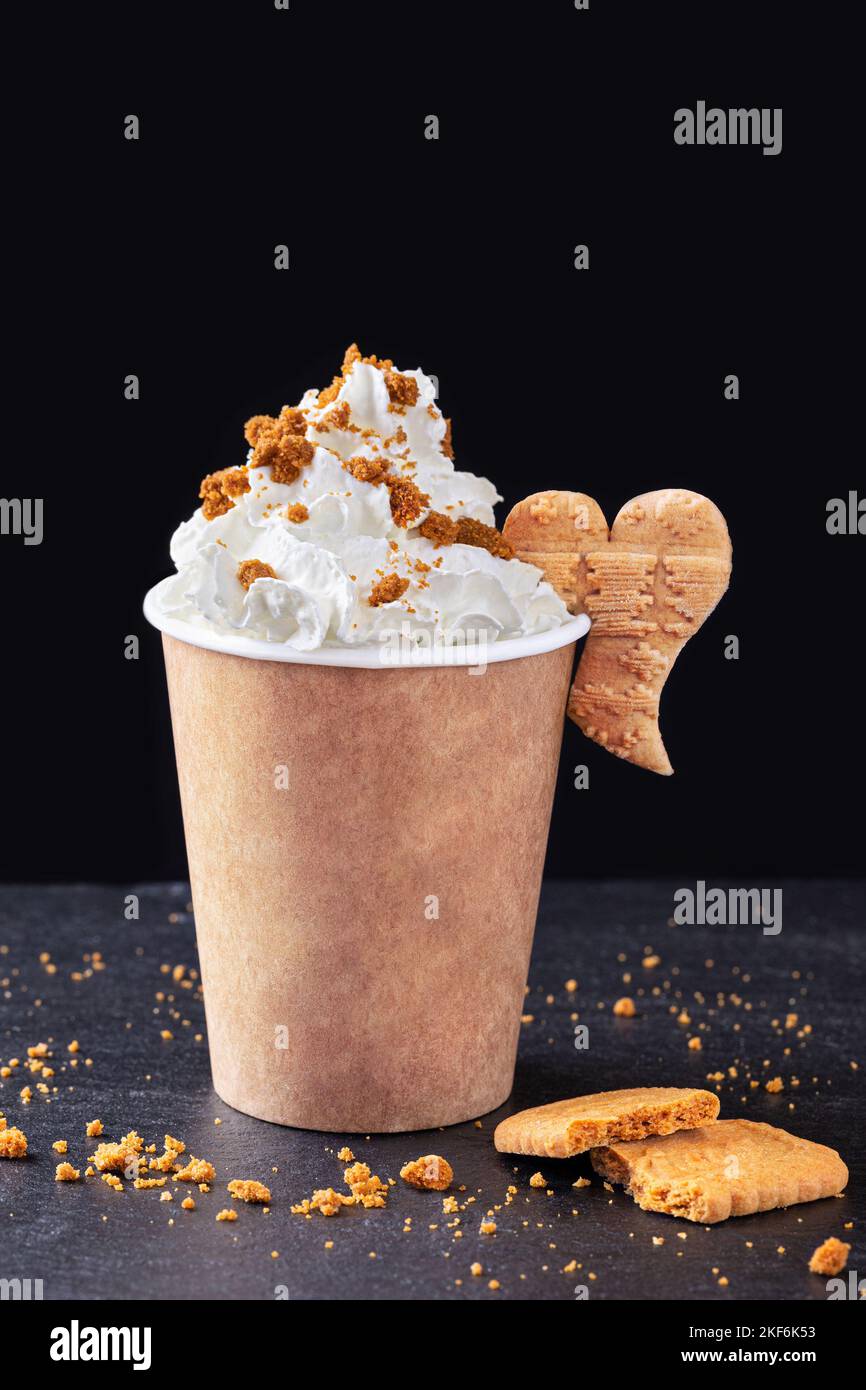 Paper cup with hot drink with whipped cream on dark background. Recycling and eco friendly
