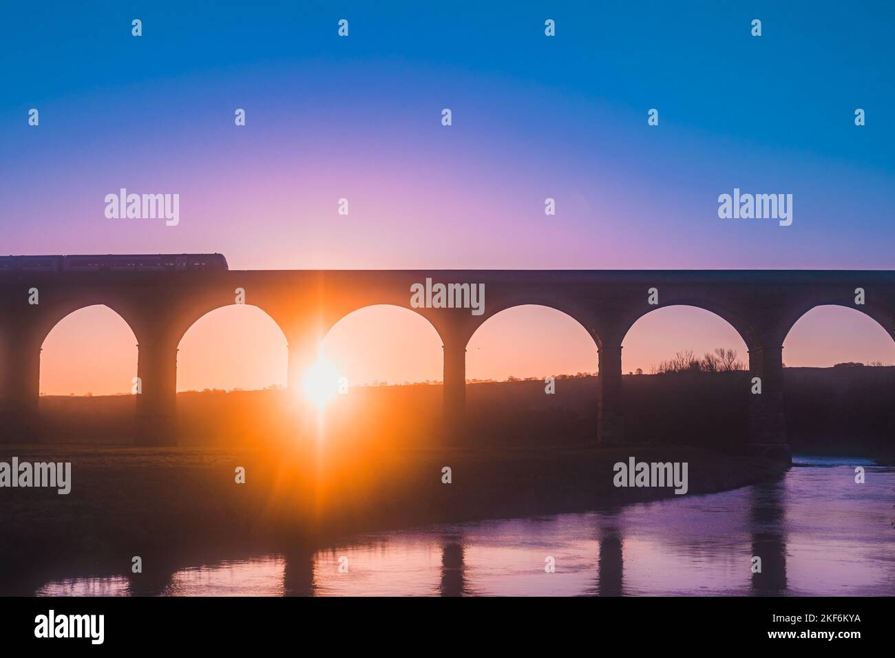 Colourful aerial view of sunrise with train travelling on Arthington Viaduct, UK Stock Photo