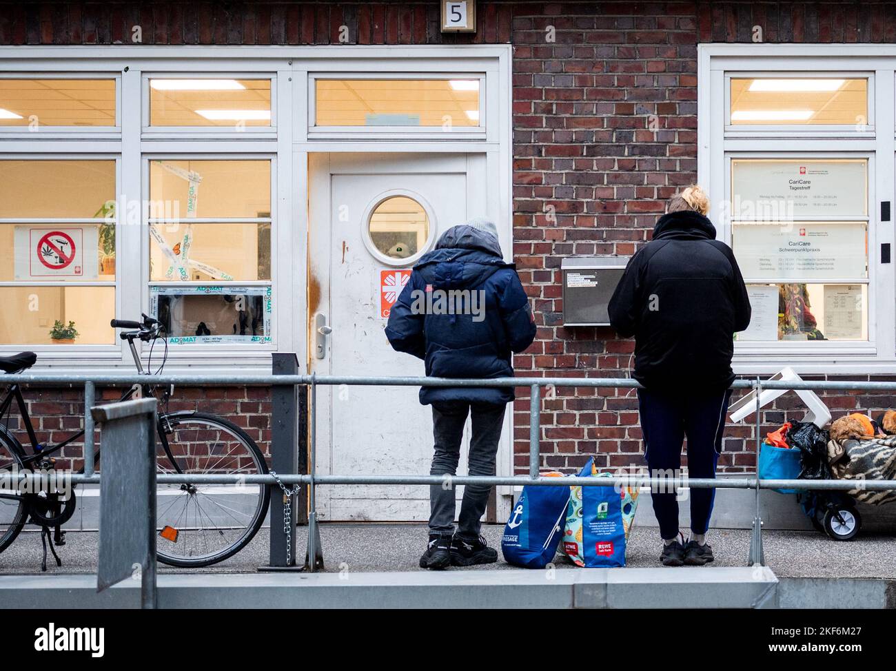 Hamburg, Germany. 16th Nov, 2022. Two men stand in front of the 'Tagestreff CariCare' in the city center. Hamburg's Caritas has opened a new facility offering a wide range of services for the homeless. Credit: Daniel Bockwoldt/dpa/Alamy Live News Stock Photo