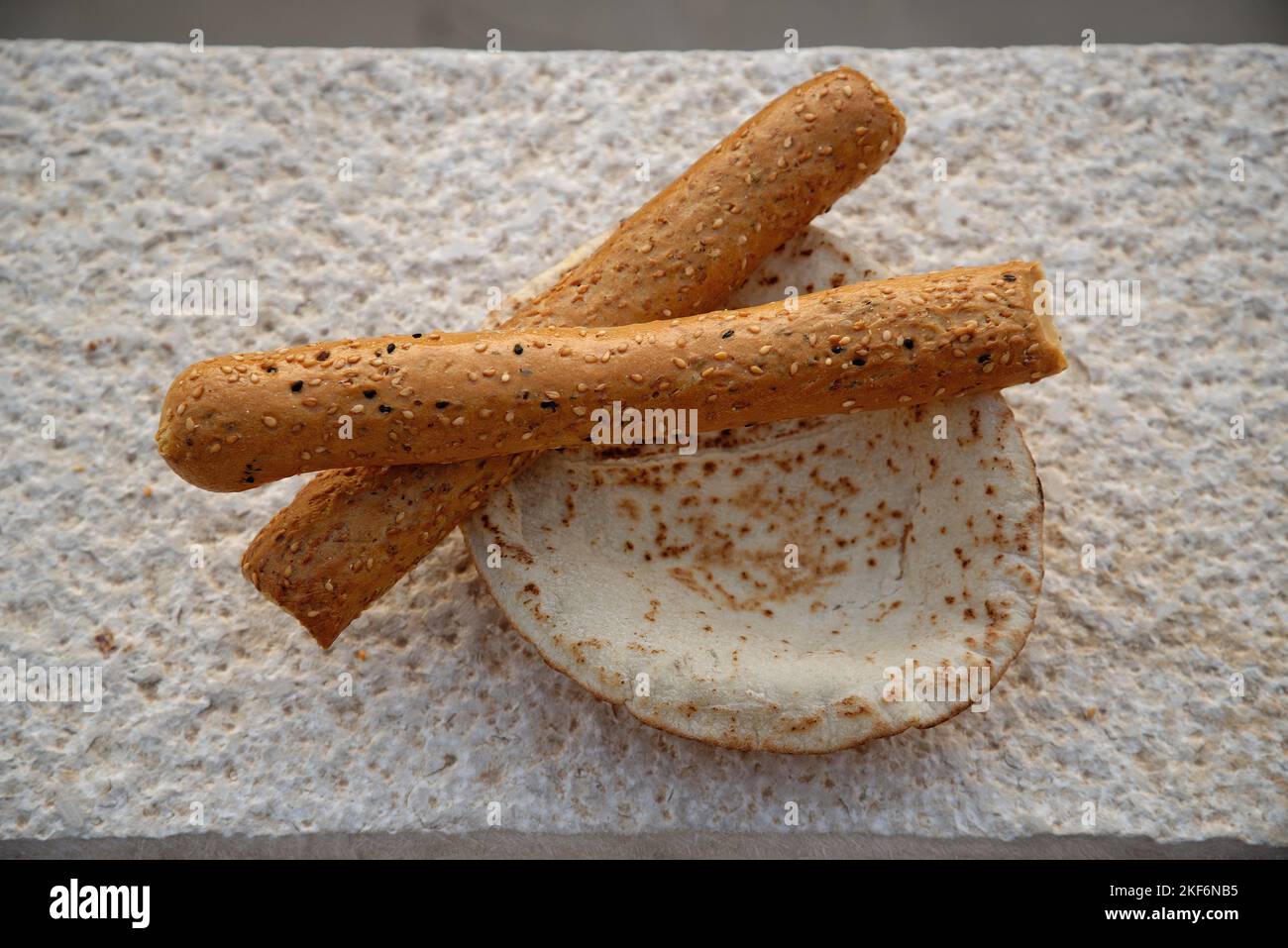 Jordanian flat bread and seeded bread sticks. Middle Eastern staple diet of wheat based food. Stock Photo