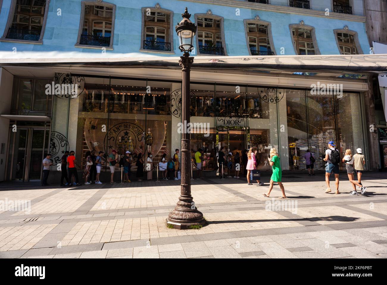Paris, France - July 16, 2022: Exterior view of Dior boutique with a row of people in the Avenue des Champs-Elysees Stock Photo