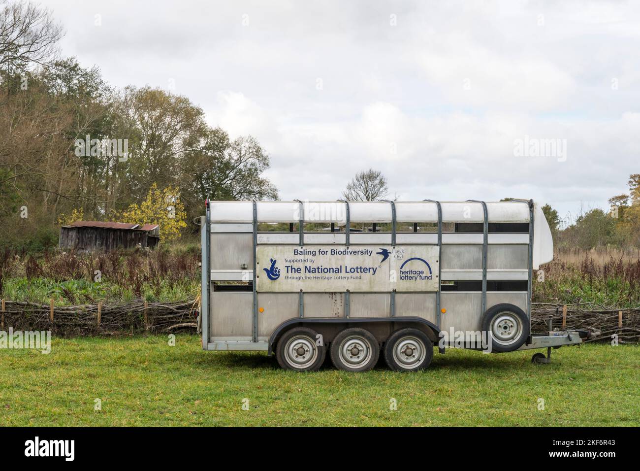 Sign on a trailer at the Hawk & Owl Trust nature reserve at Sculthorpe Moor reads Baling for Biodiversity supported by The National Lottery. Stock Photo