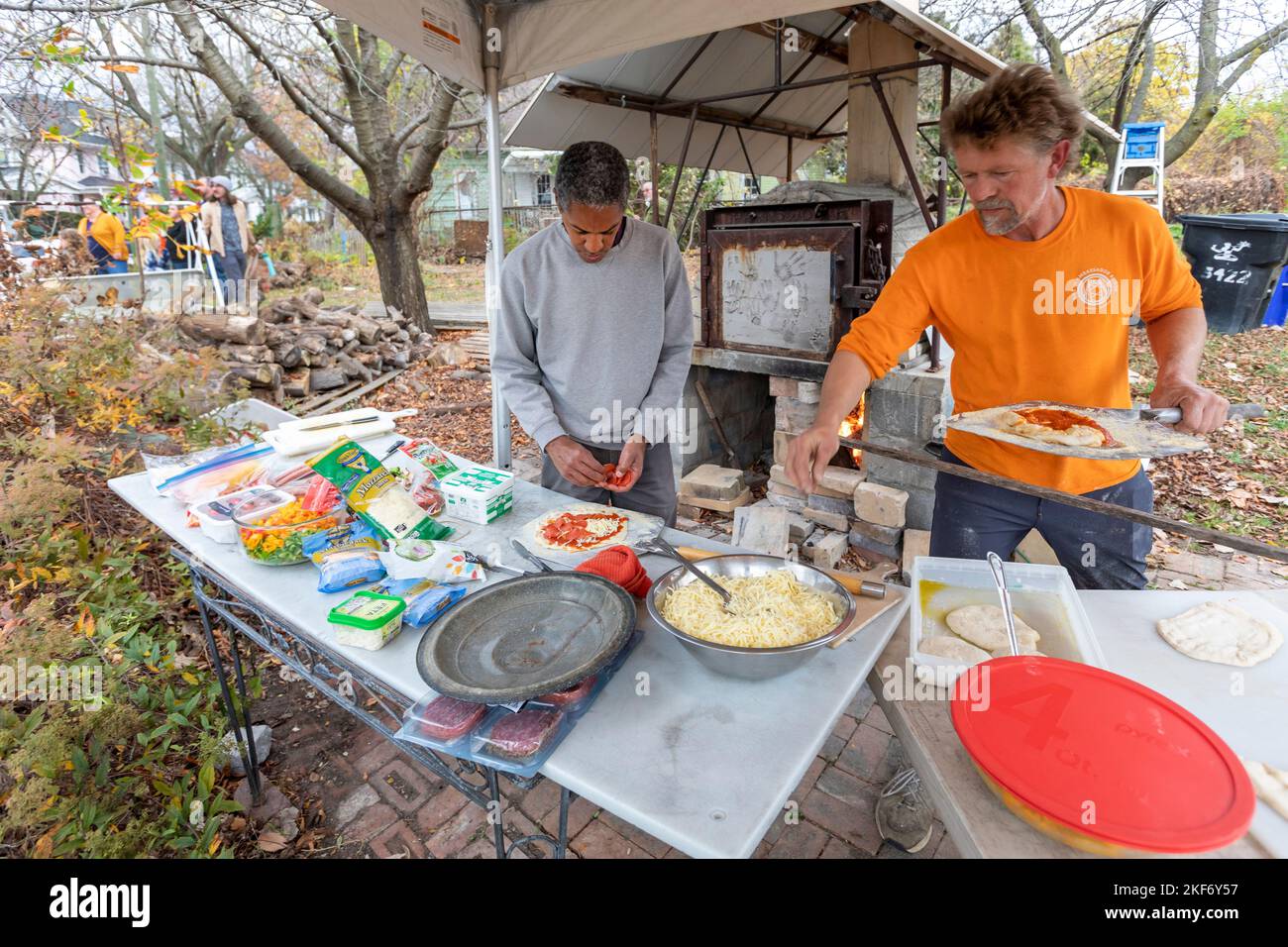 Detroit, Michigan -Two men make pizzas using an outdoor wood-fired oven at a fall festival on the near east side of Detroit. Stock Photo