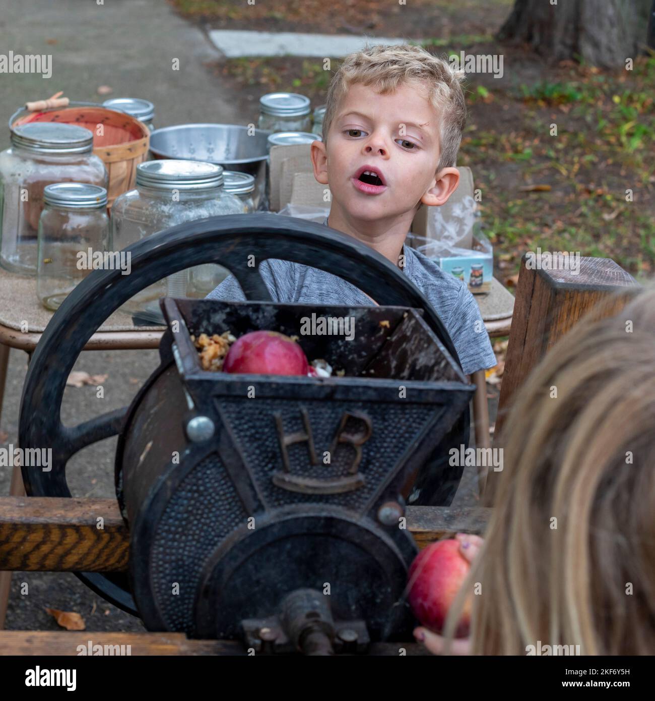 Detroit, Michigan - Children make apple cider with an apple press at a fall festival on the near east side of Detroit. Stock Photo