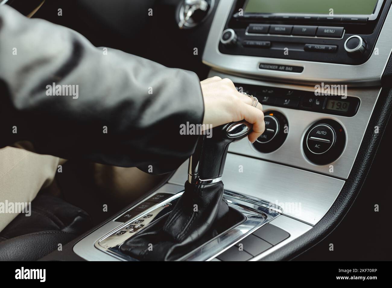Driver holds on to the shift lever of the automatic transmission. A