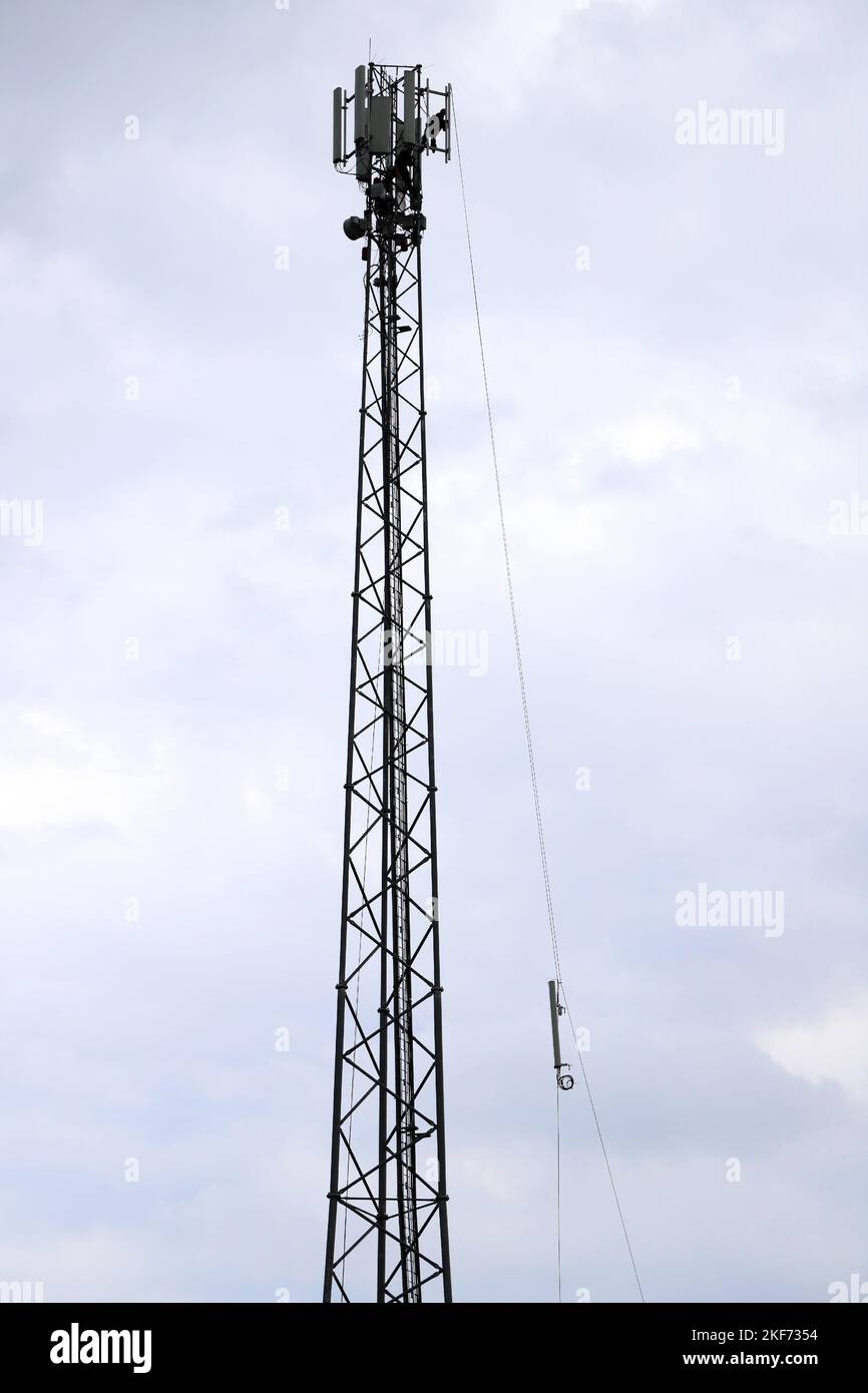 Cellphone tower, cell site, cell tower, cellular base station, cell phone tower. Installation of a cell phone relay on the tower. Stock Photo