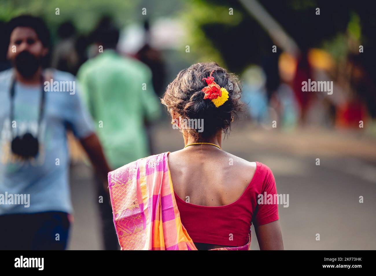 A selective focus of the Indian Hindu woman worshiping at Hindu temple in traditional clothing