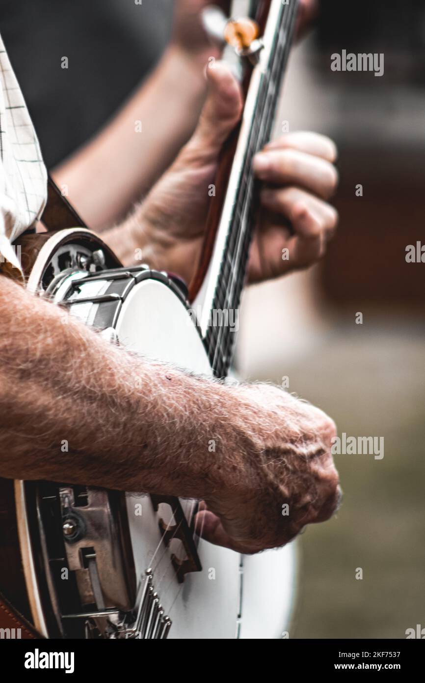 A closeup side view of man's hands playing banjo. Stock Photo